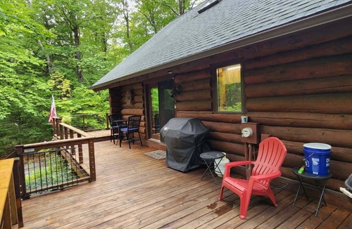Egg Harbor House | Beautiful log home with wrap-around deck surrounded by trees.