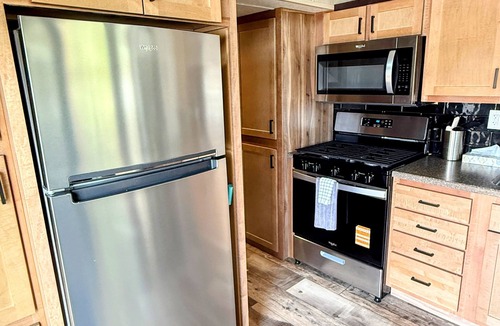 Portage RV Rental | MTM Premier - The Funky Duo combines Funky Island and Funky Jungle—two side-by-side lakefront properties sleeping 12 total. A bright park model and cozy log cabin with shared campground amenities, perfect for larger groups.