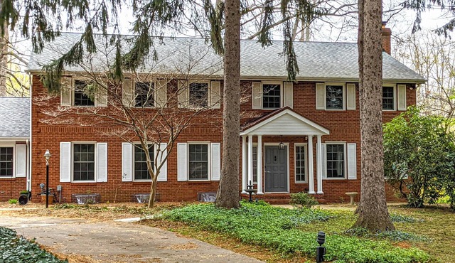 Colonial style 5BR/5BA home tucked in a private, wooded setting w/pool & hot tub